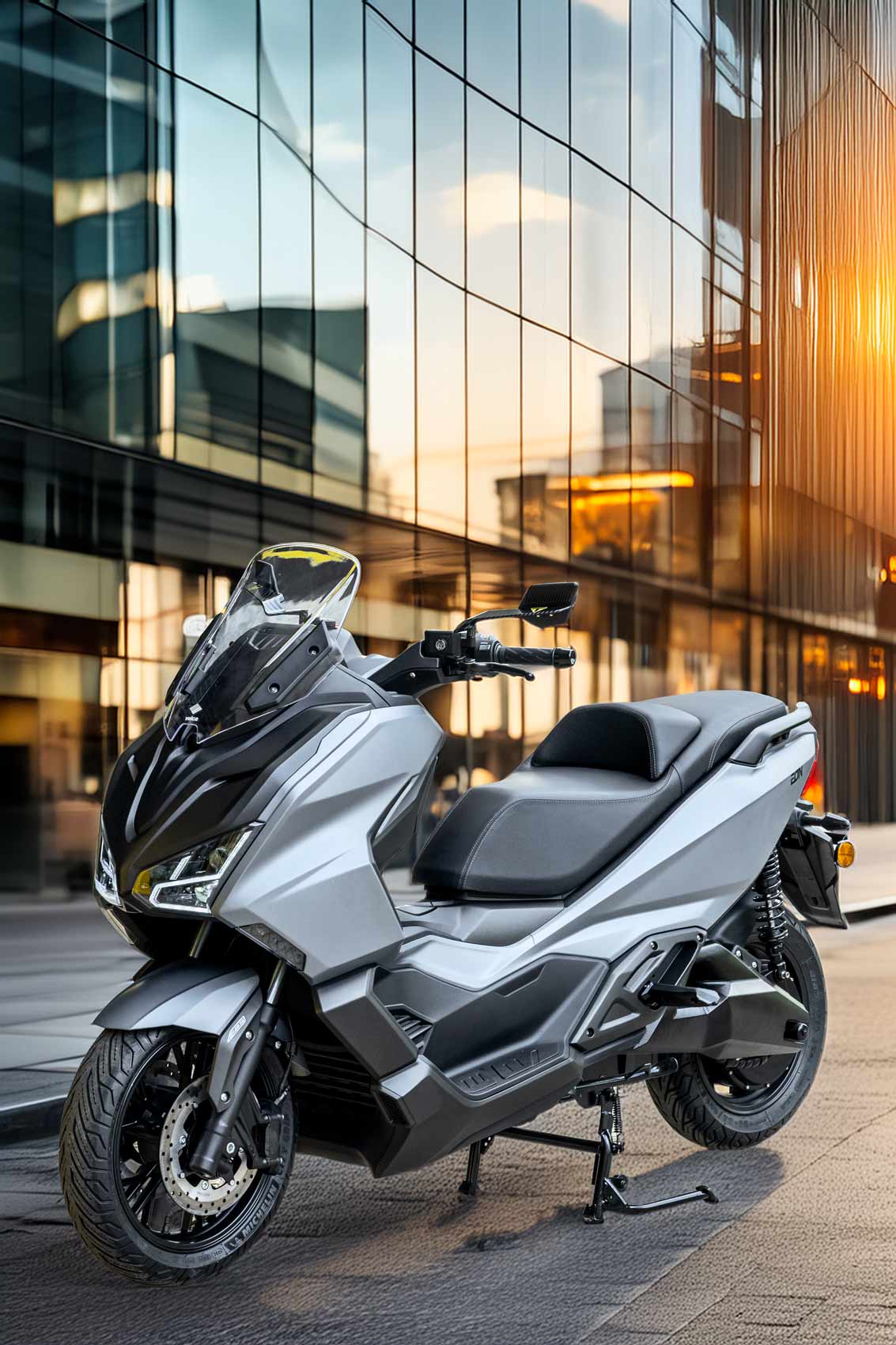 EMAX S argento, vista tre quarti anteriore parcheggiato in citt&agrave; al tramonto